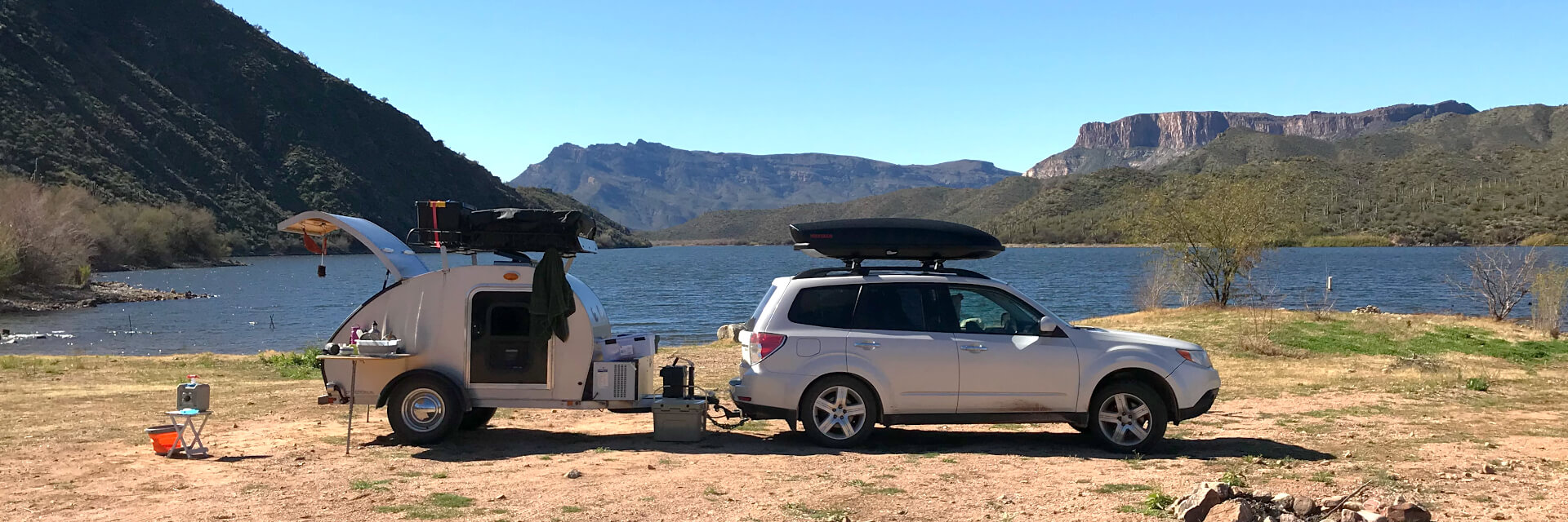 my car and teardrop trailer by a lake