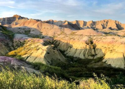 yellow purple beige badlands with grass near sunset